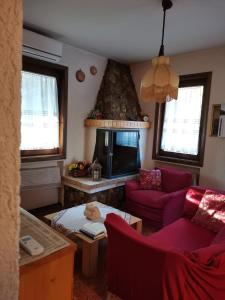 羅阿納的住宿－Elisa's Home，客厅设有红色的沙发和壁炉