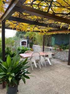 a patio with a table and chairs under a pergola at Etruscan residence Perugia in Pianello