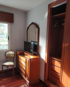 Habitación con tocador, TV y espejo. en Secondary home, en Lobios