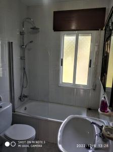 a bathroom with a shower and a tub and a sink at Secondary home in Lobios