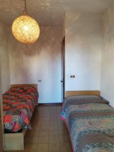 1 dormitorio con 2 camas y lámpara de araña en Elisa's Home, en Roana