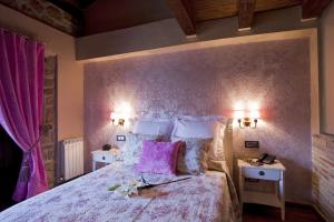 a bedroom with a large bed with a purple wall at Hotel Boutique Real Posada De Liena y Restaurante Liena in Murillo de Gállego