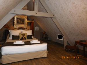 a bedroom with a large bed in a attic at Chambres et Table d'Hôtes Les Machetières in Langeais