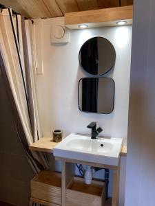 a bathroom with a sink and two mirrors on the wall at l'Observatoire de l'Aérogrange in Biscarrosse