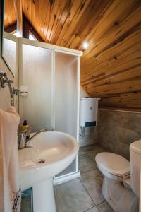 Babil Bungalow Boutique Hotel في كارتيبي: حمام مع حوض أبيض ومرحاض