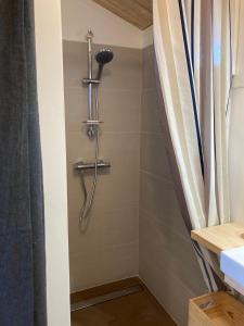a shower in a bathroom with a shower curtain at l'Observatoire de l'Aérogrange in Biscarrosse