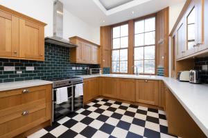 cocina con armarios de madera y suelo a cuadros en ALTIDO 5 Bedroom Apt near Meadows and George Square en Edimburgo