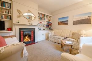 ein Wohnzimmer mit 2 Sofas und einem Kamin in der Unterkunft 18 Hartington, Aldeburgh in Aldeburgh