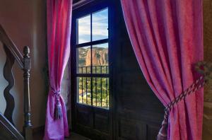 a room with a door and a window with red curtains at Hotel Boutique Real Posada De Liena y Restaurante Liena in Murillo de Gállego