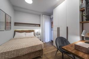 een slaapkamer met een bed en een tafel en stoelen bij Temple of PPG in Thessaloniki in Thessaloniki