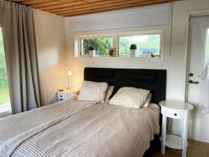 1 dormitorio con 1 cama con 2 almohadas y ventana en Lovely cottage in Bankeryd with a panoramic view of the lake en Bankeryd