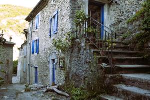 een oud stenen gebouw met blauwe ramen en trappen bij Gîte 'An Kay Ou' - L'Aiglette in Pontaix