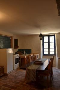 een keuken met een tafel en stoelen en een keuken met een fornuis bij Gîte 'An Kay Ou' - L'Aiglette in Pontaix
