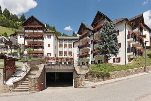 a large white building with a tree in front of it at Residence Hotel Casa Metz in Santa Cristina in Val Gardena