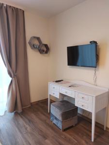 Zimmer mit einem Schreibtisch und einem TV an der Wand in der Unterkunft R&A Studio in Klaipėda