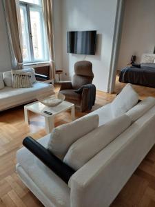 a living room with a white couch and a chair at Beautiful apartment in 7th district in Budapest