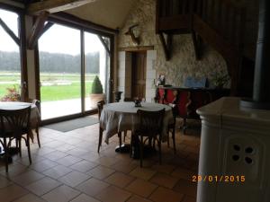 a dining room with a table and a large window at Chambres et Table d'Hôtes Les Machetières in Langeais