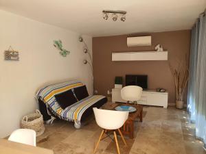 sala de estar con sofá, mesa y sillas en VILLA REVA APPARTEMENT, en Les Issambres