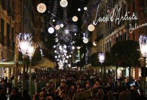 una multitud de personas caminando por una calle con luces de Navidad en La Garçonniere-Suite in Salerno centro, en Salerno