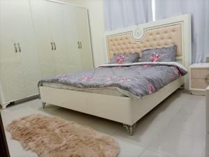 a bedroom with a bed and a rug at شقة غرفتين وصاله ابراج الؤلؤه in Ajman 