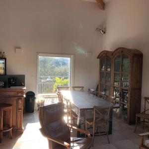 ein Esszimmer mit einem Tisch, Stühlen und einem Fenster in der Unterkunft Villa de charme avec piscine entre Ajaccio et Porticcio in Eccica-Suarella