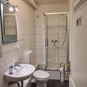 een badkamer met een douche, een toilet en een wastafel bij Altstadt Hostel Bremen in Bremen
