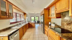 a large kitchen with wooden cabinets and a dining room at 27 @ Wozani Ridge in Hibberdene