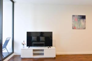 una sala de estar con TV en un armario blanco en Sydney CBD Modern 2 bedroom Apartment, en Sídney