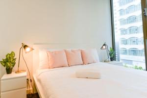 1 dormitorio con 1 cama blanca y ventana en Sydney CBD Modern 2 bedroom Apartment en Sídney