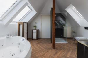 a bathroom with a white bath tub in a attic at H Villa Herkules in Świnoujście
