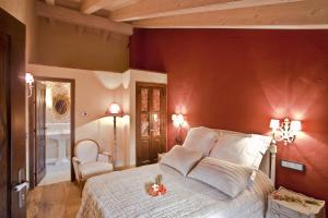 a bedroom with a white bed with a red wall at Hotel Boutique Real Posada De Liena y Restaurante Liena in Murillo de Gállego