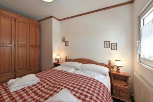 una camera con un letto con una coperta rossa e bianca di Residence Hotel Casa Metz a Santa Cristina in Val Gardena