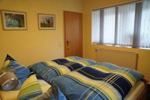 Una cama con sábanas azules y amarillas y una ventana en Ferienwohnung Splitek, en Kurort Altenberg