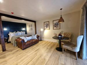 1 dormitorio con 1 cama, mesa y sillas en West Highland Hotel, en Mallaig