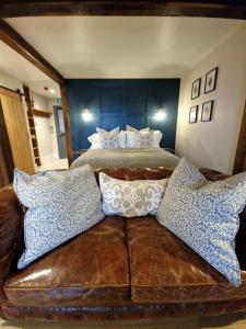 ein Schlafzimmer mit einem Bett und einem braunen Ledersofa in der Unterkunft West Highland Hotel in Mallaig