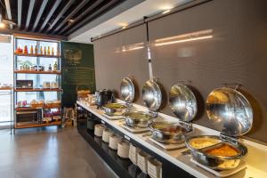 a buffet line in a restaurant with pots and pans at Chaiin Hotel - Dongmen in Taipei +29 photos