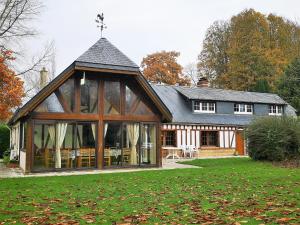 a large house with a large conservatory in the yard at Le Moment Normand in Émalleville