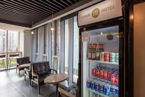 a drink cooler in a restaurant with a table and chairs at Chaiin Hotel - Dongmen in Taipei