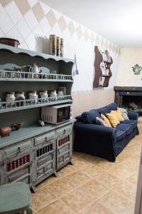 - un salon avec un canapé bleu et une étagère dans l'établissement Casa Cueva Picoesquina, à Guadix