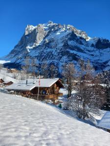 a log cabin in the snow with a mountain at Chalet Pfyffer - Mountain view in Grindelwald