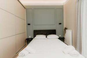 een slaapkamer met een groot wit bed met 2 kussens bij Satus Finem Egnatia's Luxury Apartment in Thessaloniki