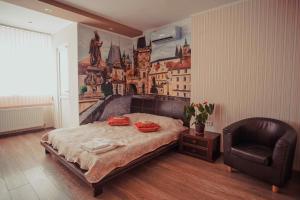 a bedroom with a large bed and a chair at Molex Apartments in Chernihiv