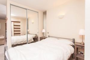 a bedroom with a white bed and a mirror at Awesome apartment in the heart of Camden Town in London