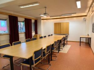 une grande salle de conférence avec une grande table et des chaises dans l'établissement Hotell Samegård, à Kiruna