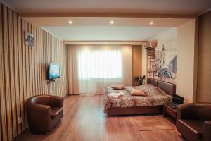 a bedroom with a bed and a chair and a television at Molex Apartments in Chernihiv