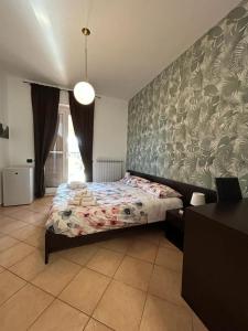 a bedroom with a bed with a floral wallpaper at B&B Verdeoliva in Modugno