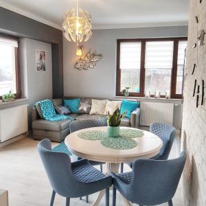 a living room with a table and chairs at Apartamenty City Center - Zdrojowe in Krynica Zdrój