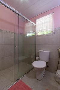ein Bad mit einem WC und einer Glasdusche in der Unterkunft Suítes Valdira in Arraial d'Ajuda