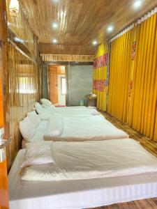 Un grupo de 4 camas en una habitación en Hoa Chanh Eco Home en Sa Pa