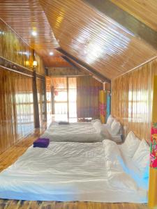 a bedroom with two beds in a wooden room at Hoa Chanh Eco Home in Sa Pa
